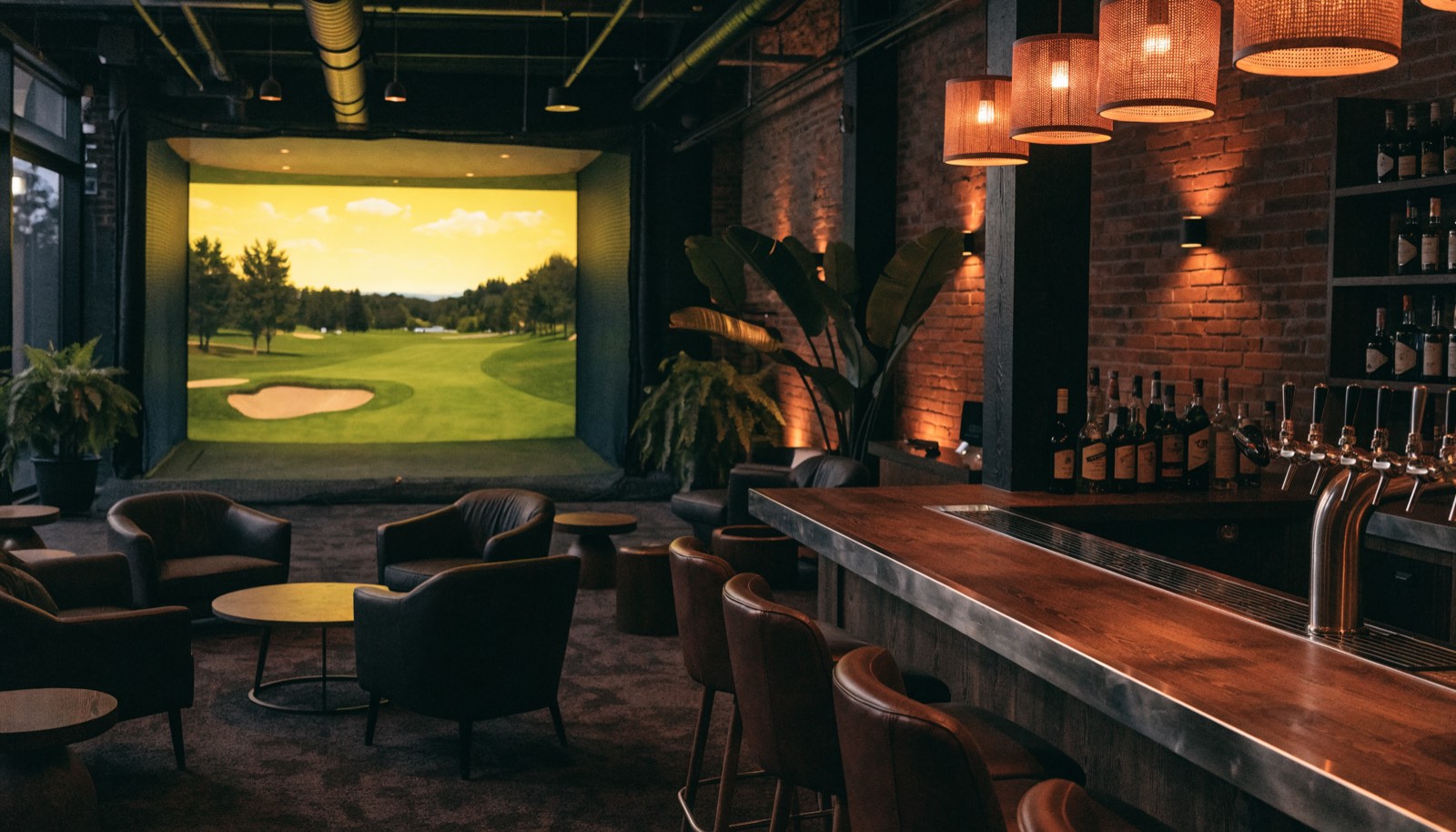 Bar and lounge seating facing an indoor golf simulator screen